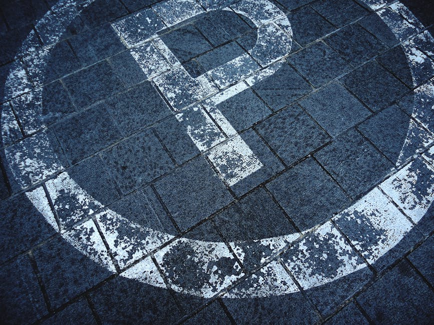 A person holding a small rectangular sticker featuring the HTML5 logo, which consists of a white number '5' inside an orange shield shape with a white border, and the word 'HTML' in bold black letters