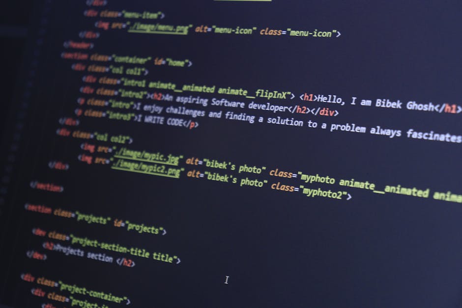 The image displays a close-up view of a computer screen with lines of code in various colors, including yellow, blue, red, and white, against a dark background. The code appears to be HTML or similar